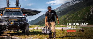 Man walking with a Rally Bag next to an off-road vehicle in a mountainous landscape with Labor Day sale text overlay.